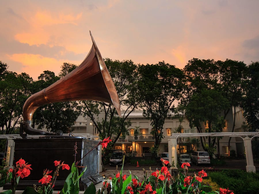 A large, metallic sculpture in an outdoor setting with a building in the background.