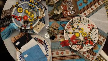 A table with various decorative items including plates, beads, and textiles.