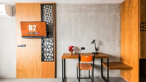 A compact room with a wooden desk, a chair, and a television mounted on a wooden panel. - B2 Khon Kaen Boutique & Budget Hotel (Khon Kaen)