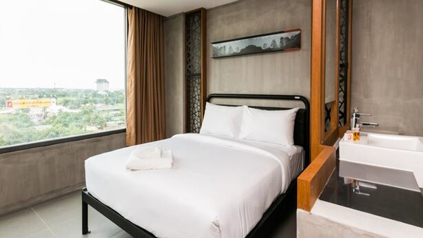 A modern hotel room with a large bed, a bathroom with a bathtub, and a city view. - B2 Khon Kaen Boutique & Budget Hotel (Khon Kaen)