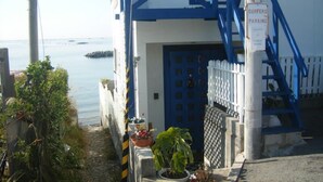 A building with a blue door and a sign indicating surfers parking. - Guest House Lohas Home (Akashi)