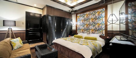 A modern hotel room with a large bed, a sofa, a desk, and a ceiling with a floral design.