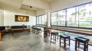 A spacious room with a large window, a bench, and several stools. - B2 Chiang Rai Boutique & Budget Hotel (Chiang Rai)