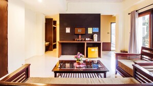 A modern hotel lobby with a reception desk, a coffee machine, and a small refrigerator. There are wooden chairs and a glass-top table with a decorative item on it. - B2 Chiang Rai Boutique & Budget Hotel (Chiang Rai)