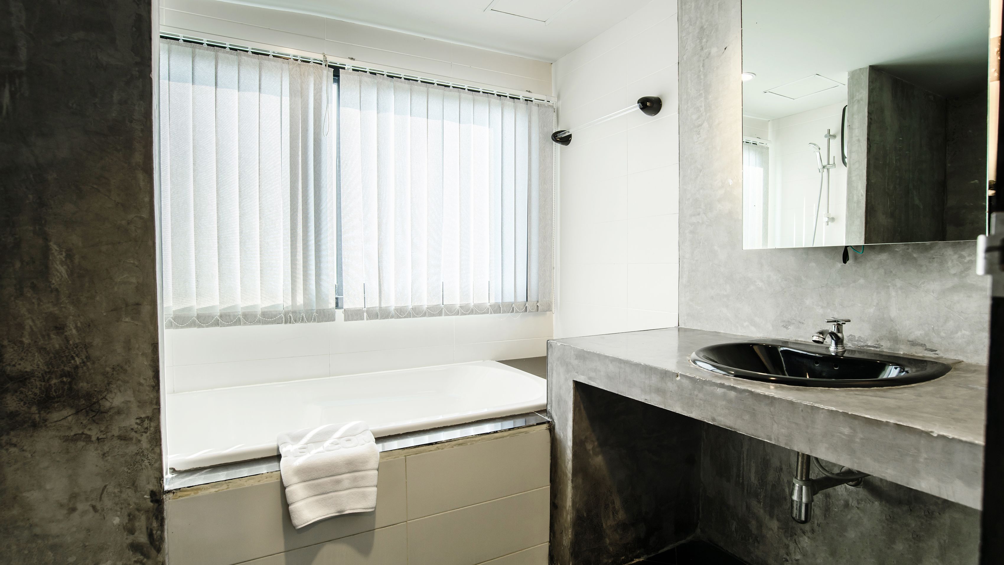 A modern bathroom with a large window, a sink, and a mirror.
