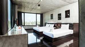 Une chambre d’hôtel moderne avec deux lits, une grande fenêtre et un plafond en béton.