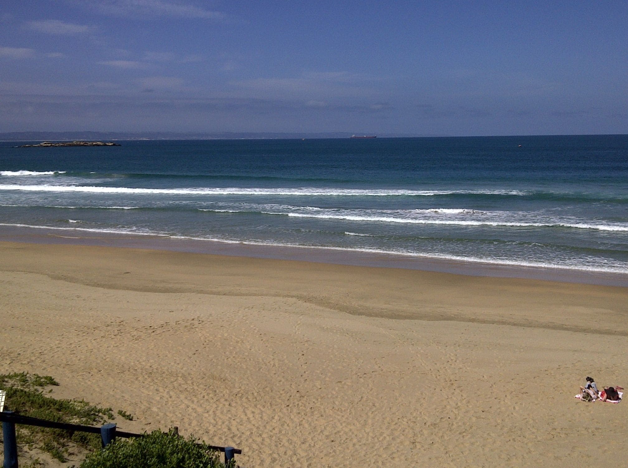 A beach with a sandy shore and waves.
