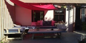 Un espace extérieur aménagé avec un canapé, deux fauteuils et une table.