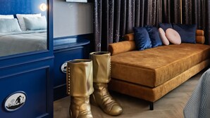 A bedroom with a bed, a sofa, a wardrobe, and a pair of boots. - Efteling Wonder Hotel - Theme Park tickets included (Kaatsheuvel)