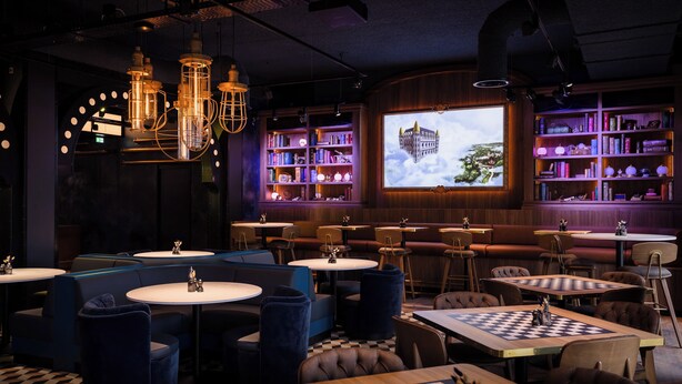 A cozy lounge area with round tables, blue cushioned seating, and a chessboard. - Efteling Wonder Hotel - Theme Park tickets included (Kaatsheuvel)