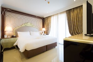 Une chambre d’hôtel avec un grand lit, deux tables de chevet avec des lampes, un téléviseur à écran plat et un bureau.