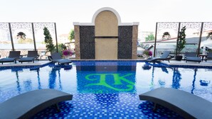 Una piscina amb sòl de rajola i una paret decorativa al centre.
