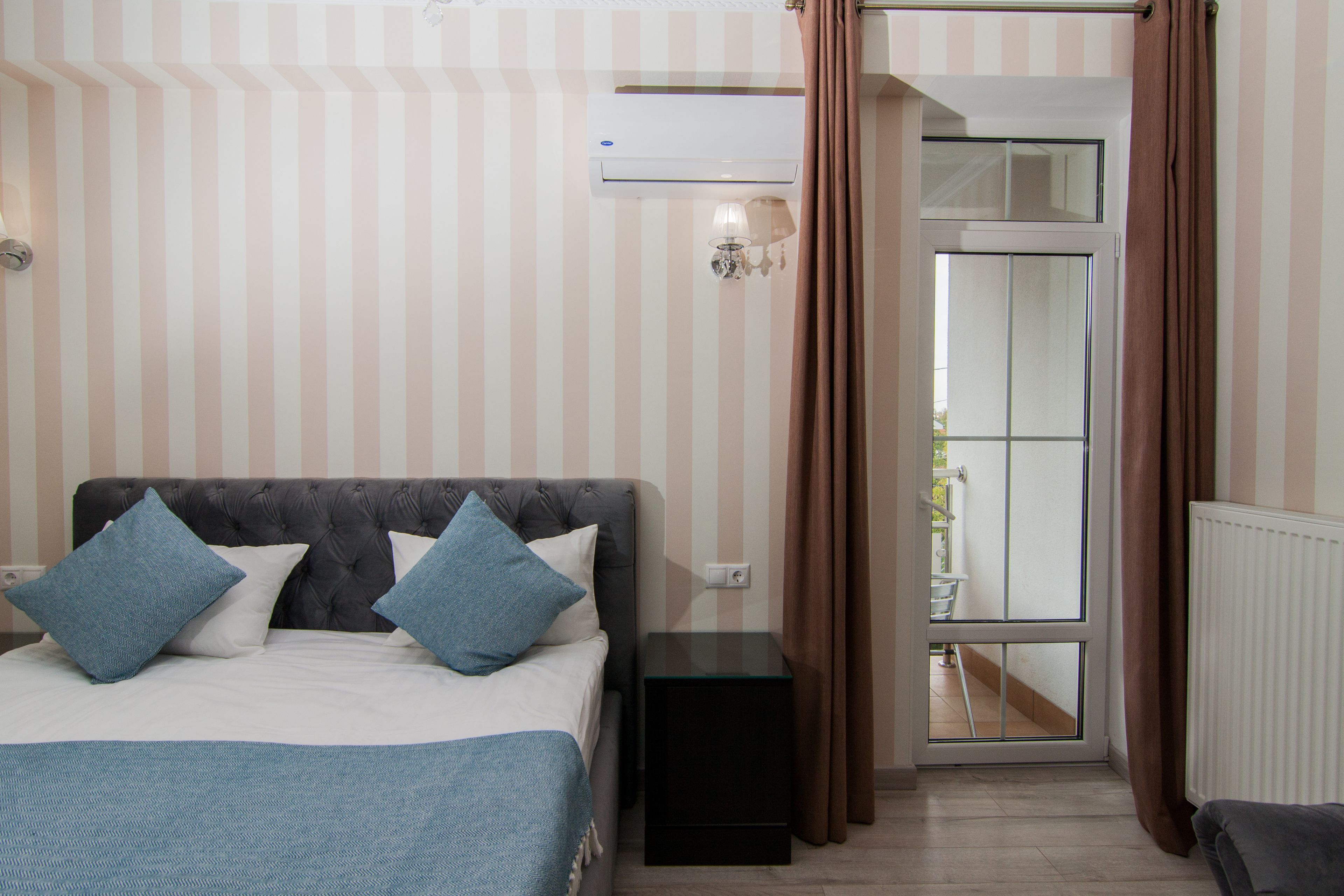Une chambre à coucher avec un lit, une table de chevet et une fenêtre avec des rideaux.
