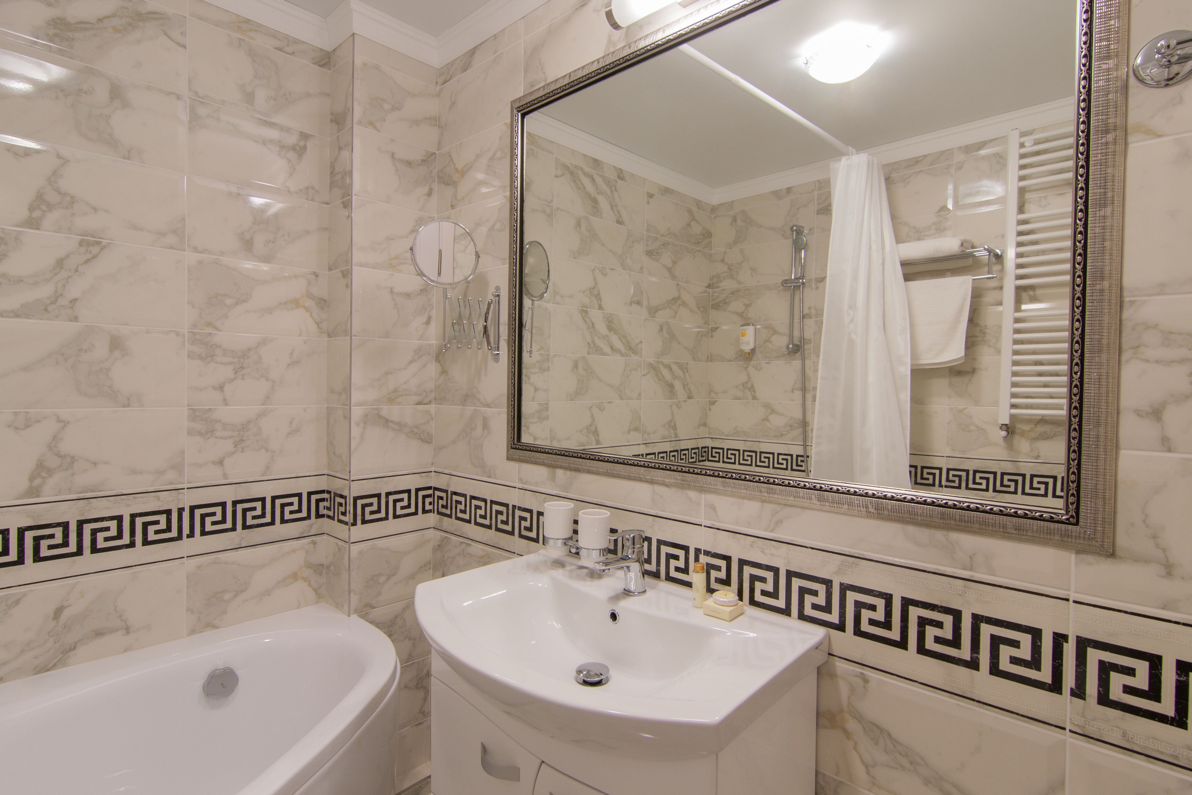 A bathroom with a bathtub, sink, and mirror.