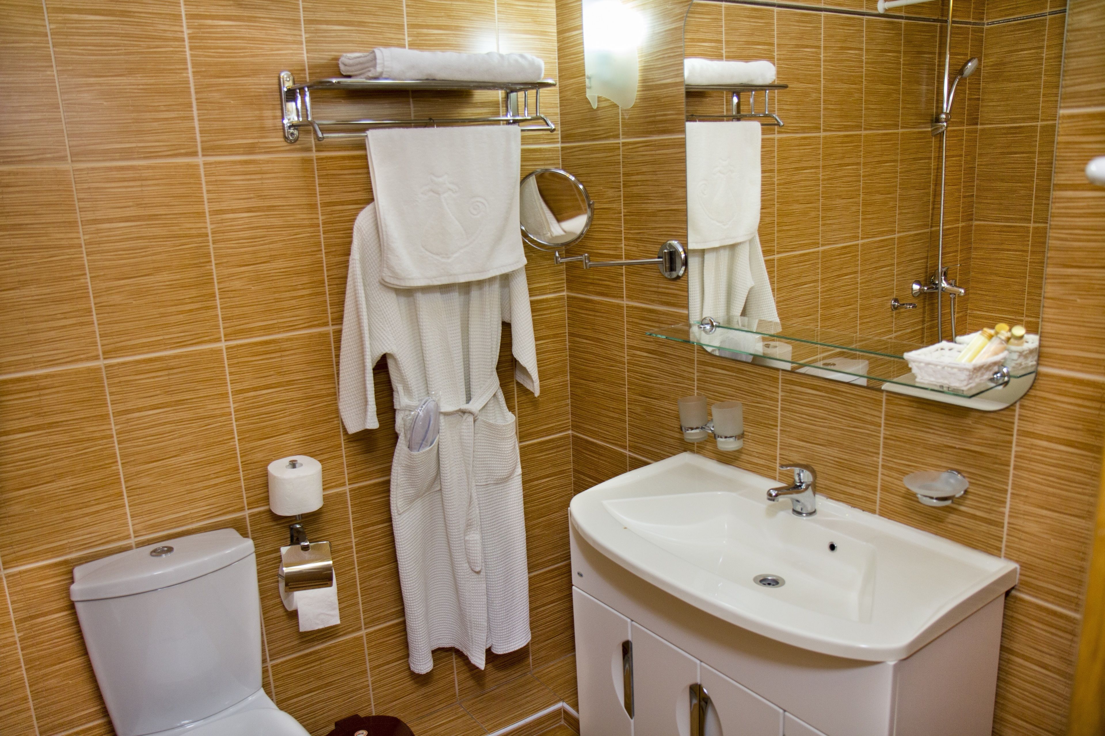 Un baño con inodoro, lavamanos y perchero para toallas.