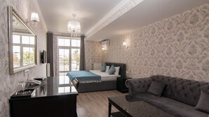 A modern bedroom with a bed, a sofa, a desk, and a large mirror. - Klassik Hotel (Chisinau)