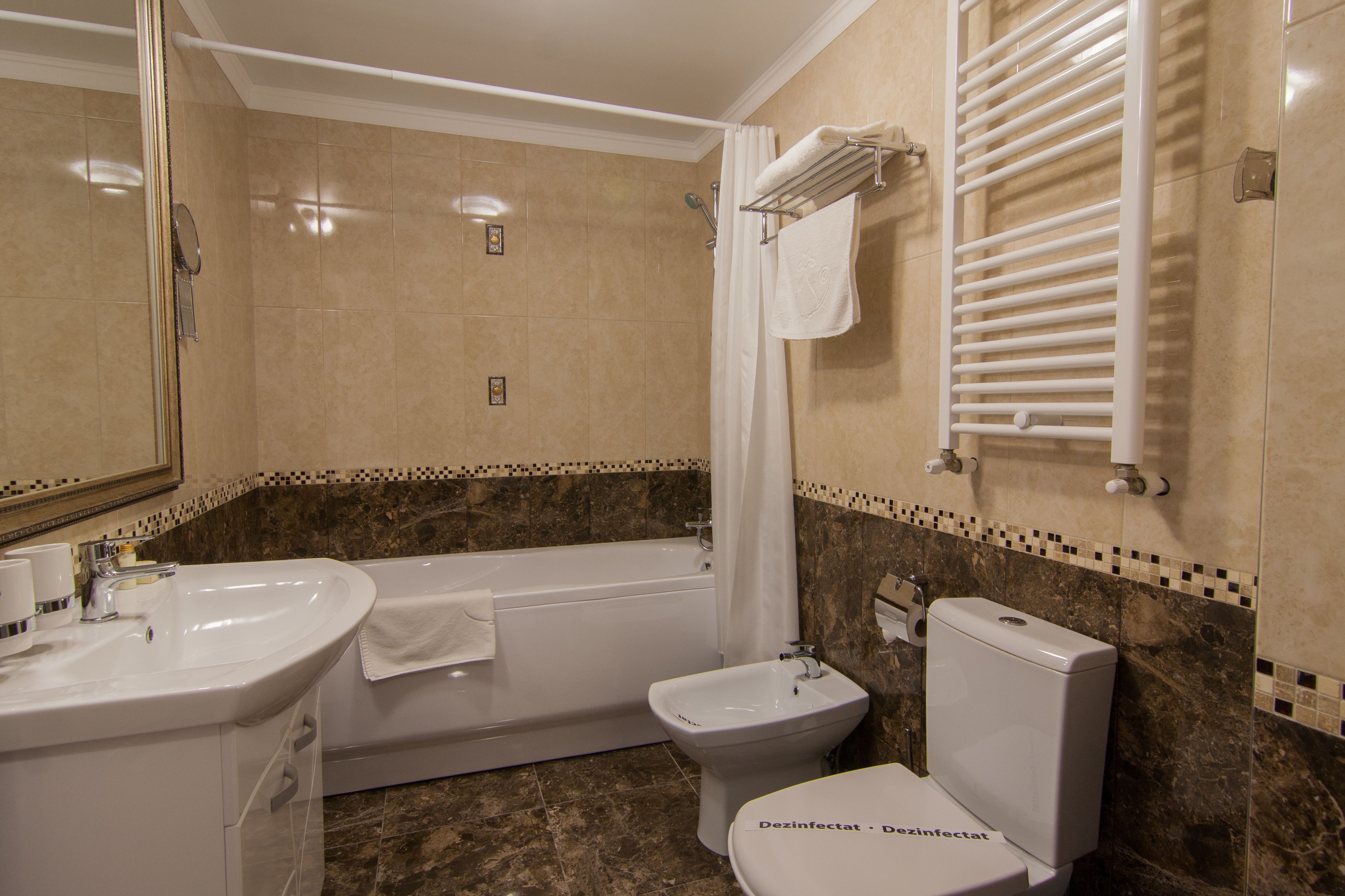 Une salle de bain équipée d’une baignoire, d’un lavabo, de toilettes et d’un bidet.