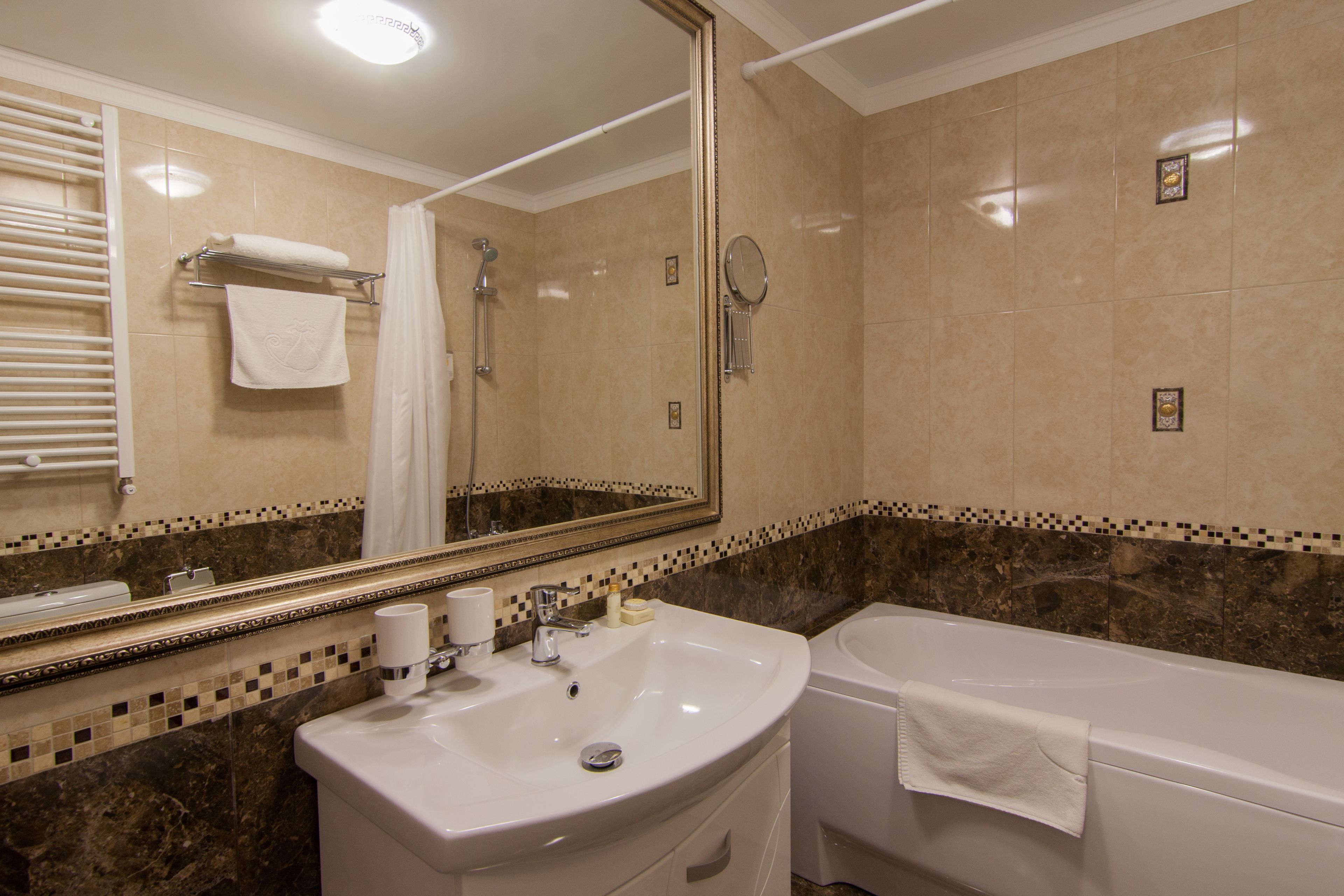 A bathroom with a sink, mirror, shower, and bathtub.