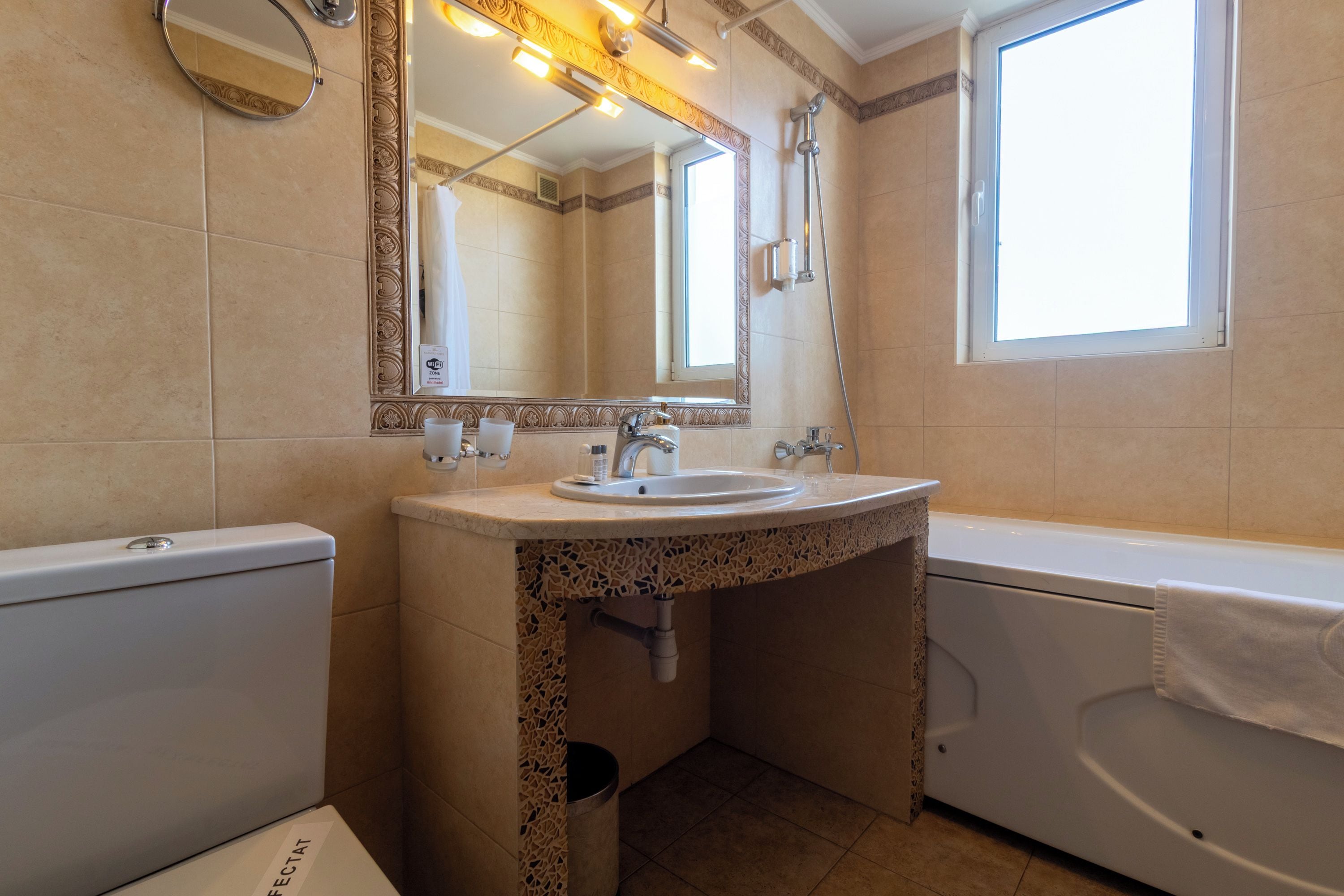 Une salle de bain équipée d’un lavabo, d’un miroir, de toilettes et d’une baignoire.