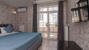 A bedroom with a bed, a radiator, a window, and a view of the outside.