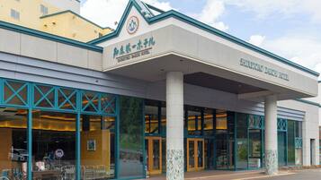A hotel with a modern facade, large windows, and a prominent logo.