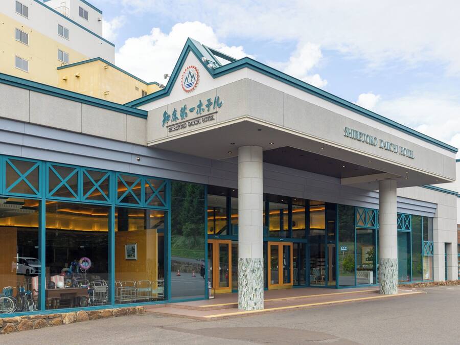 A hotel with a modern facade, large windows, and a prominent logo.