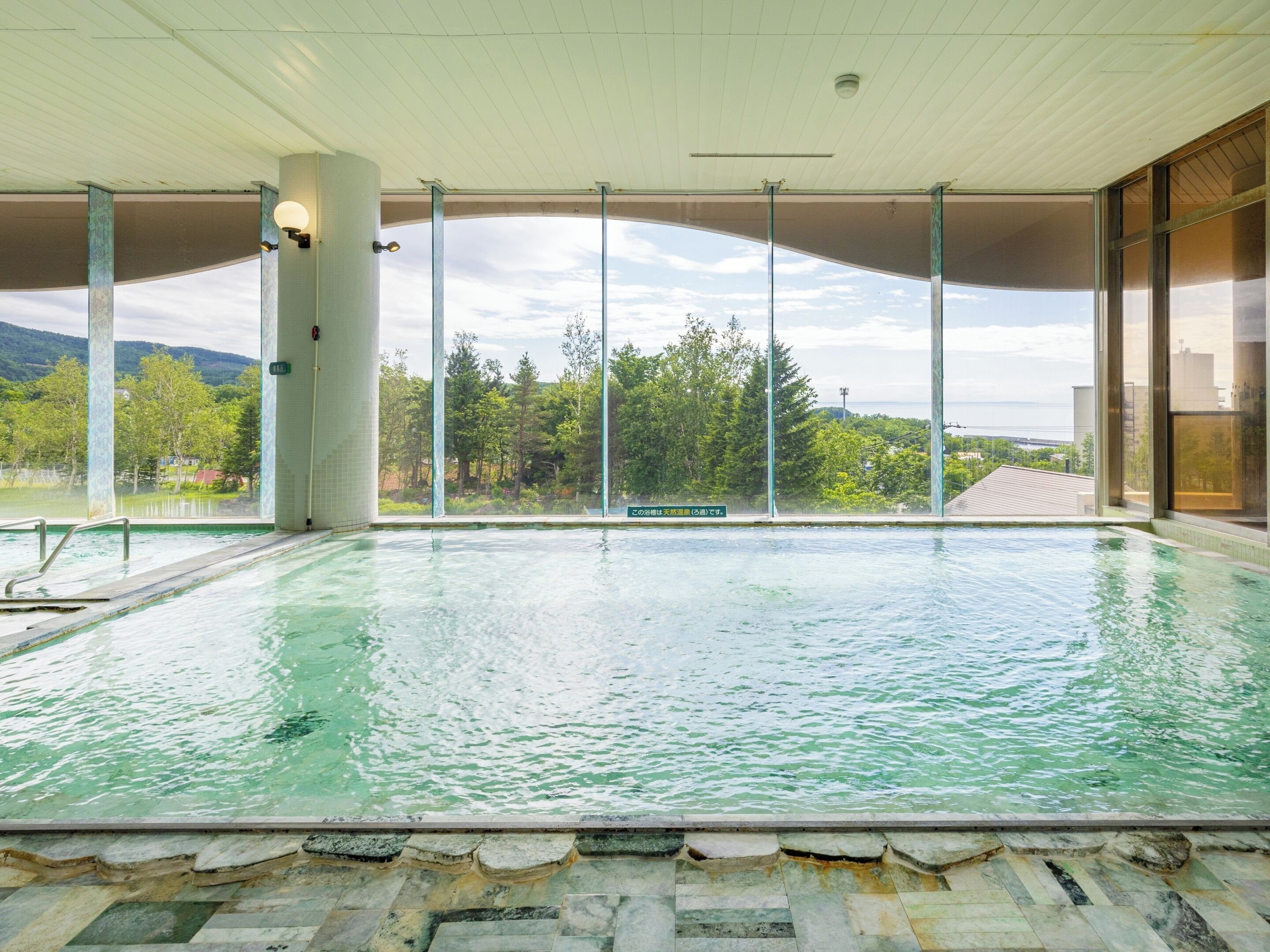 An indoor swimming pool with clear views of the surrounding landscape.