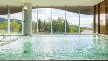 An indoor swimming pool with clear views of the surrounding landscape.