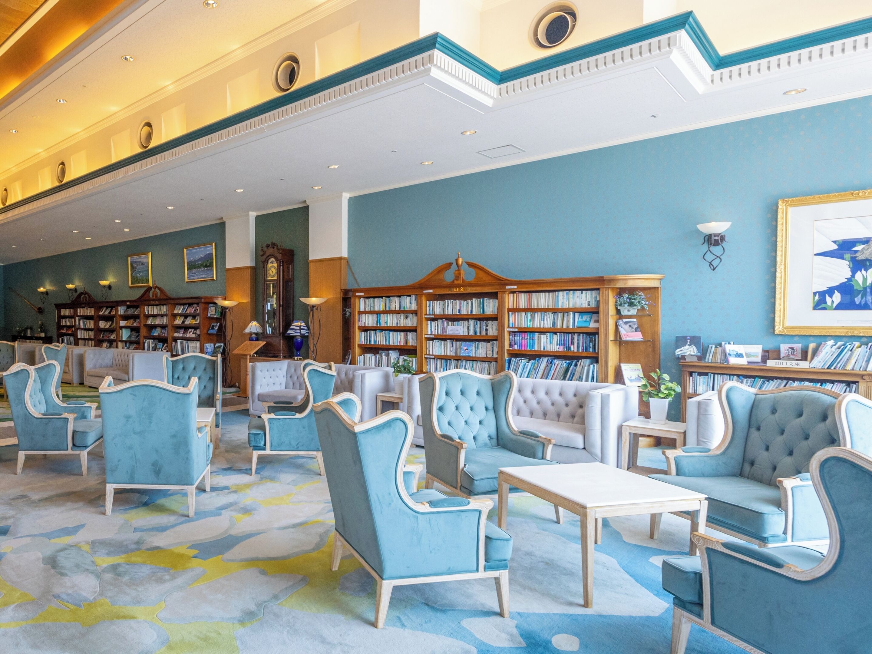A spacious library with multiple seating areas and bookshelves.