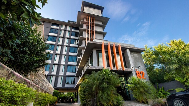 Un edificio moderno con varios pisos, ventanas amplias y un letrero naranja destacado.