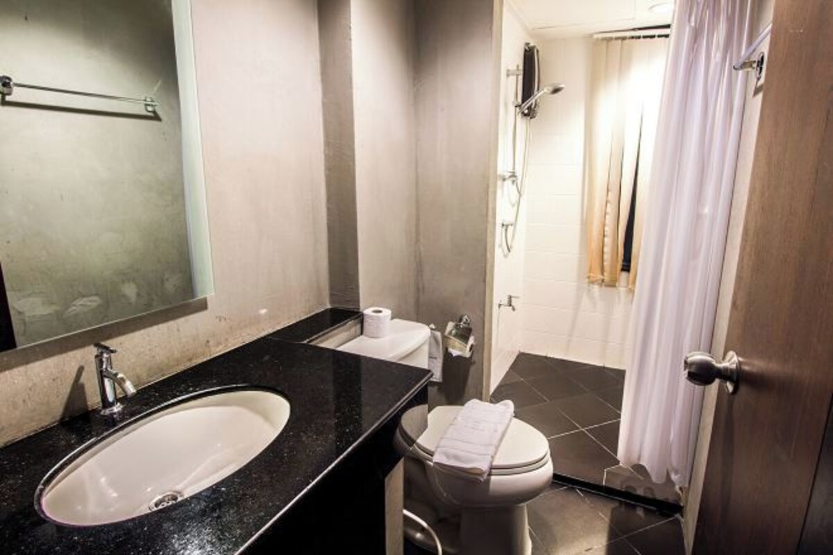 A bathroom with a sink, toilet, and shower area.
