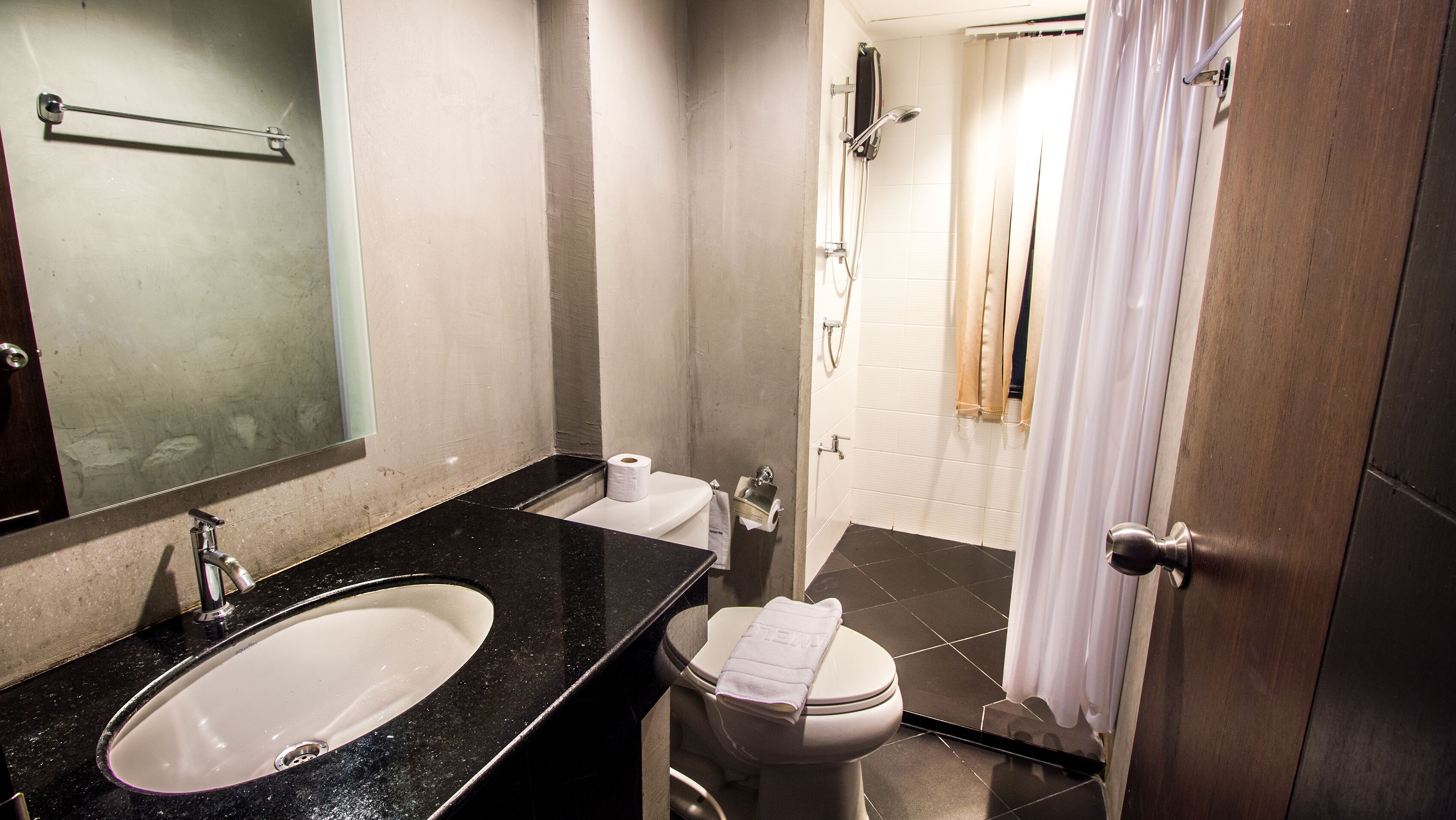 Un baño con lavamanos, inodoro y zona de ducha.