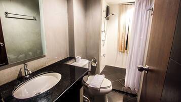 A bathroom with a sink, toilet, and shower area.
