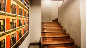 Una escalera con escalones de madera y una pared con un mural colorido.
