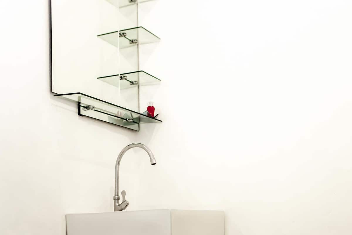 A bathroom with a white sink, a mirror above it, and a toilet.