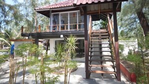 A wooden structure with a red roof, a balcony, and a staircase leading to an upper level. - Phangan Cove (Ko Pha-ngan)