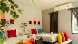 A hotel room with two beds, a bedside table with a vase of flowers, and an air conditioning unit. - Phangan Cove (Ko Pha-ngan)