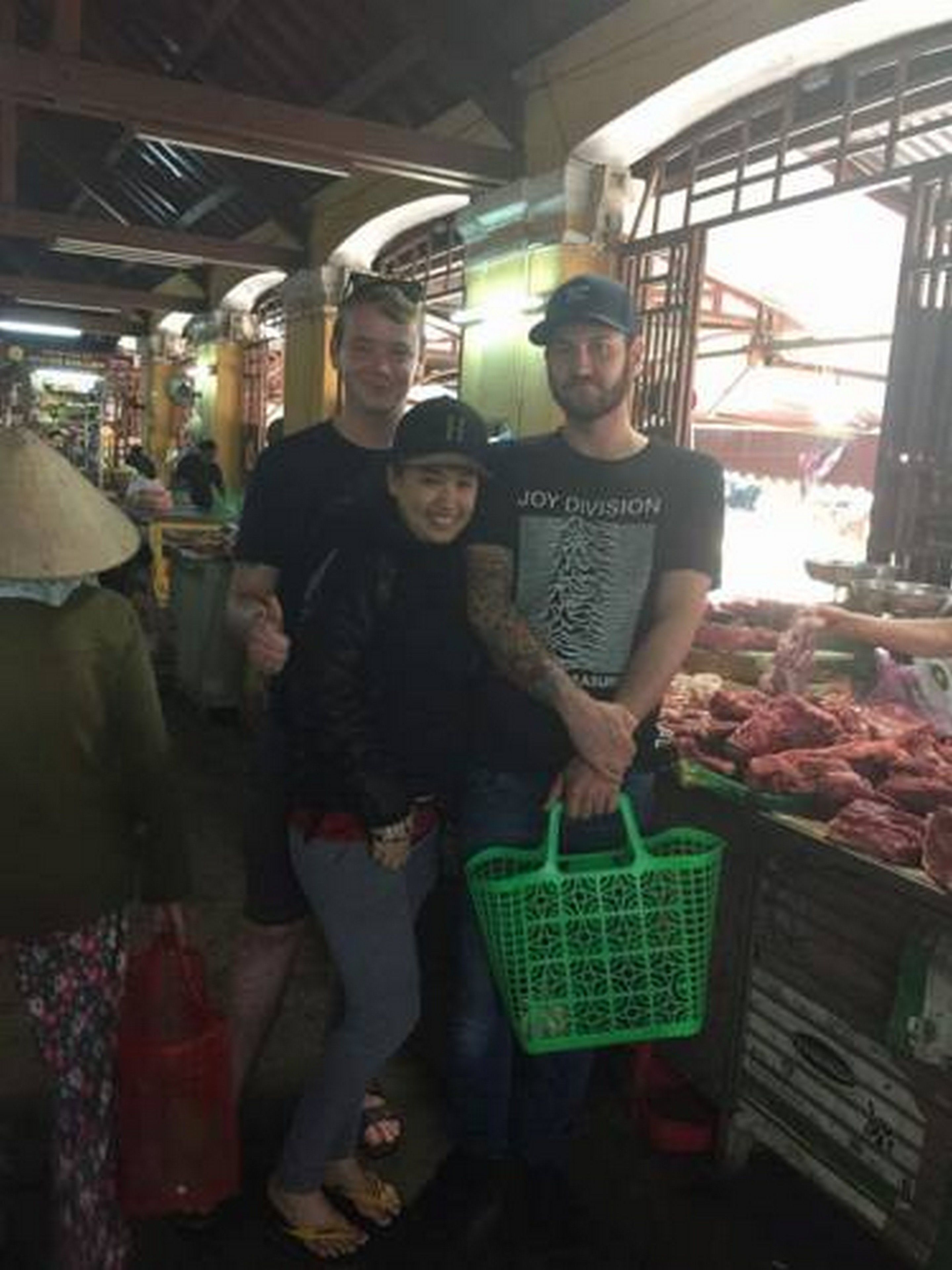 A market with people standing and shopping.