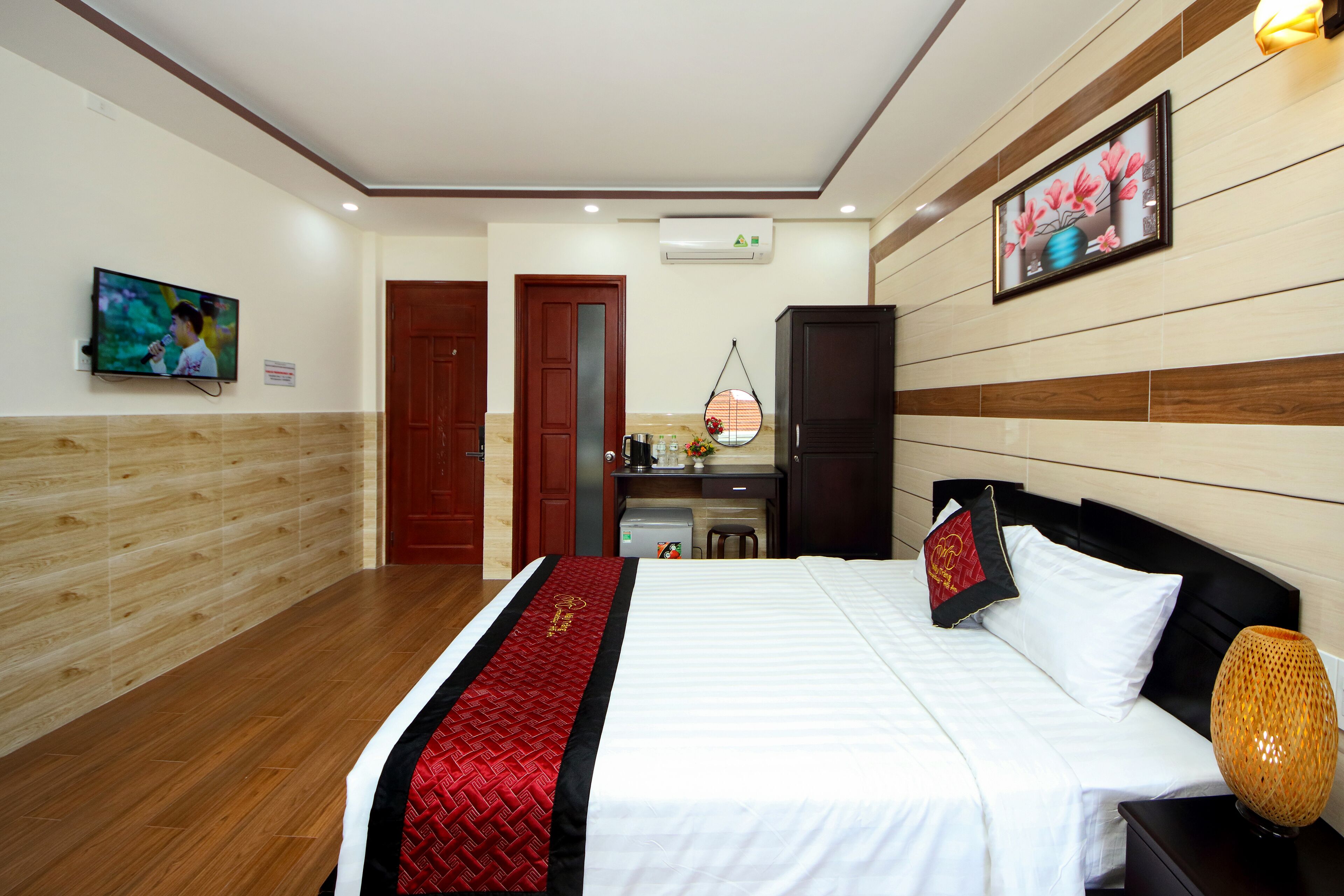 A hotel room with a bed, a desk, and a TV.