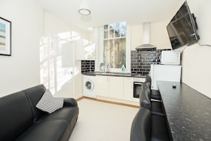 Standaard appartement, 3 slaapkamers | Woonruimte | Een 40-inch flatscreentelevisie met kabelzenders en een televisie