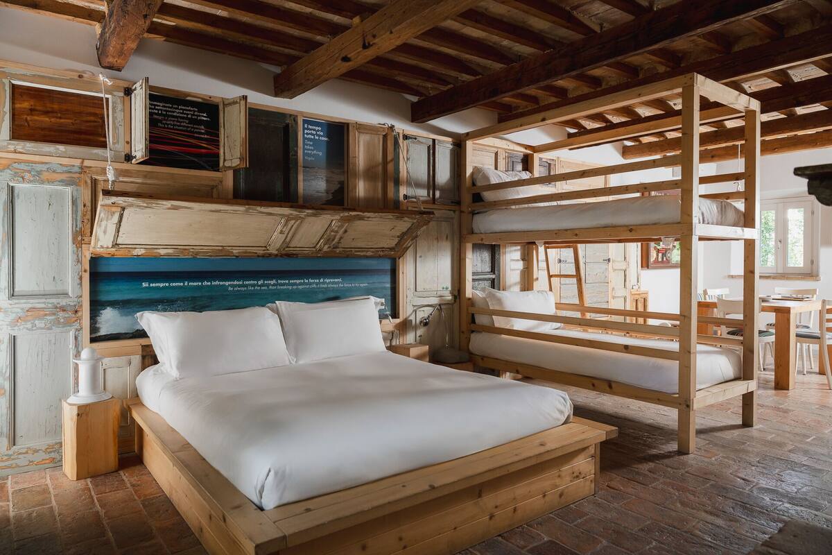 Ein rustikaler Raum mit einem Etagenbett, einem Holzkopfteil und einem Backboden.