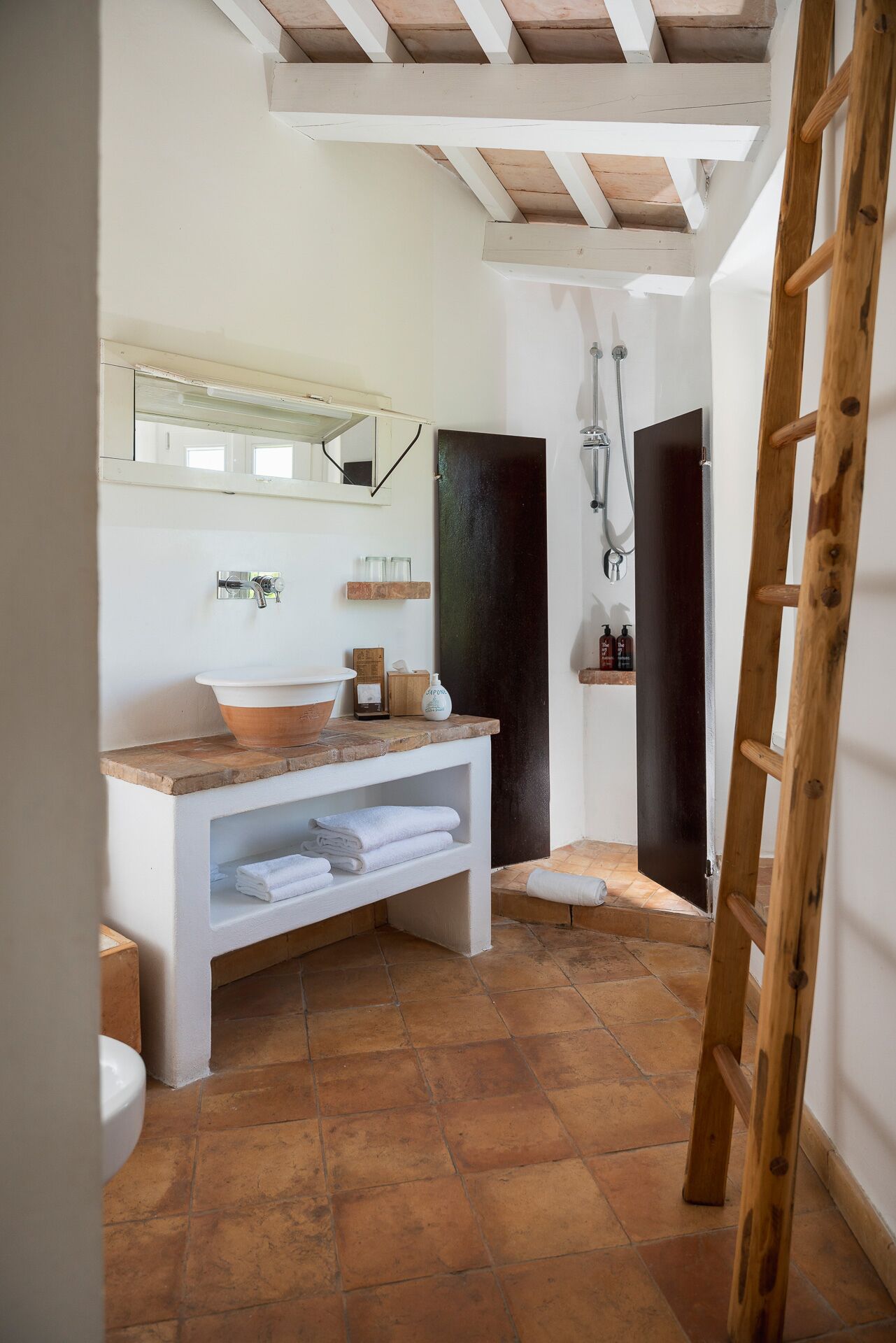 A bathroom with a wooden vanity, a large mirror, a bathtub, and a shower.