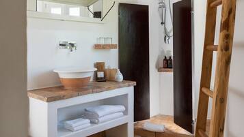 A bathroom with a wooden vanity, a large mirror, a bathtub, and a shower.