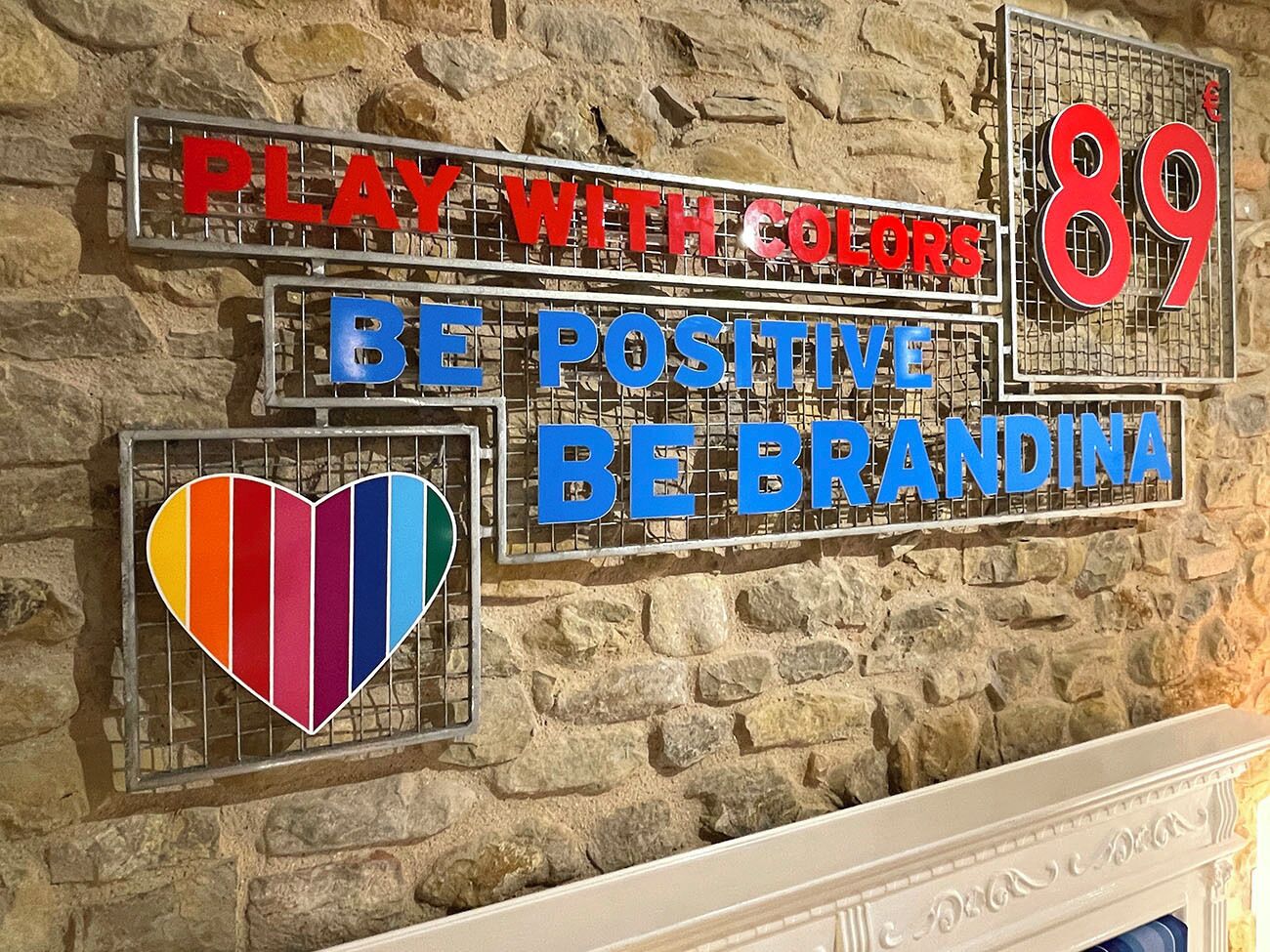 Un muro decorato con insegne motivazionali e una decorazione a forma di cuore.