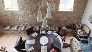 Un coin repas au style rustique, avec une table ronde, des chaises en cuir et un luminaire suspendu.