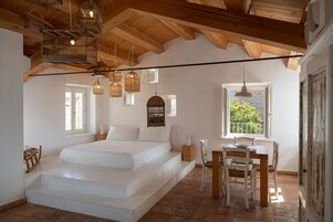 A bedroom with a bed, a desk, and a window with a view.