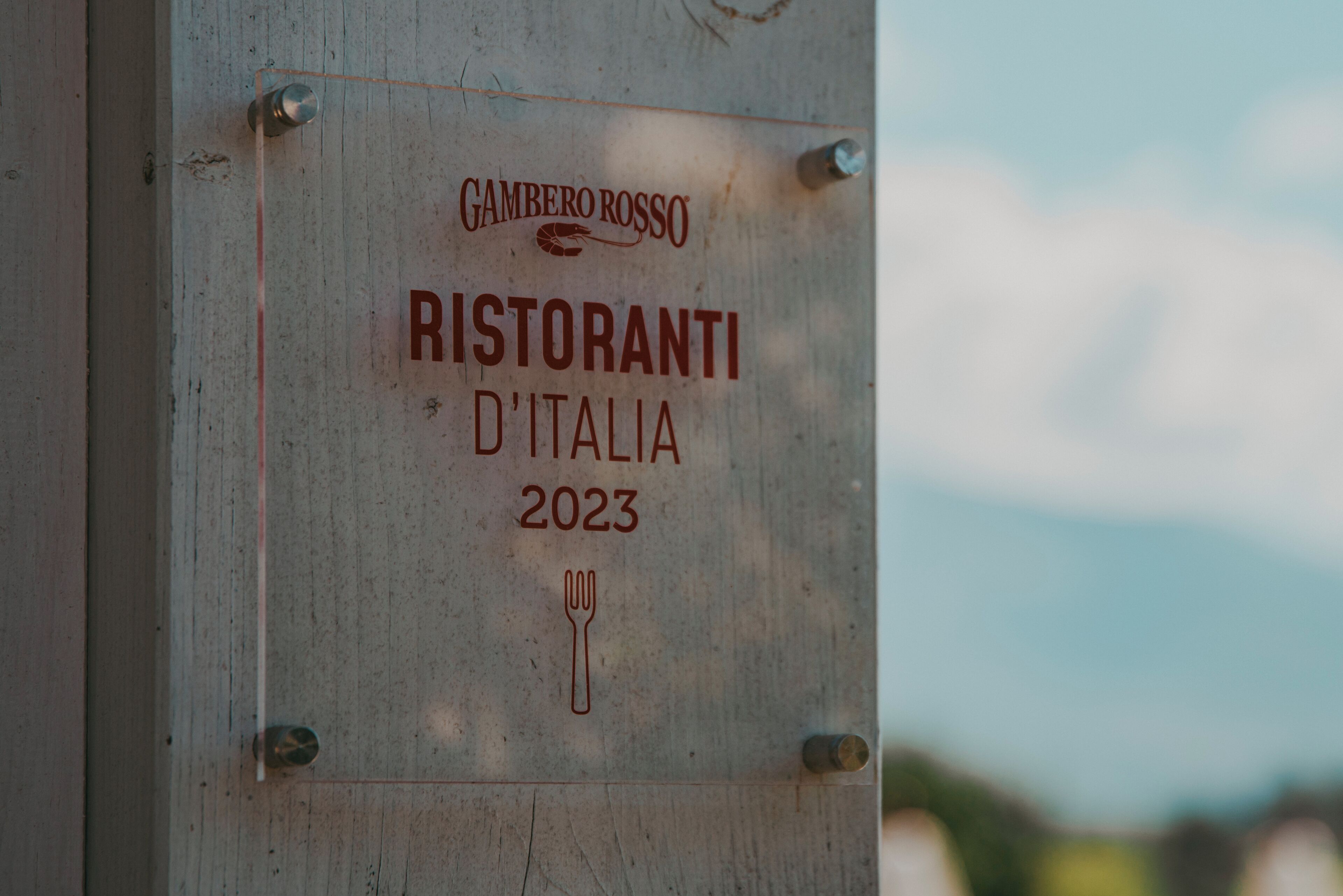 Segnale con il testo 'Gambero Rosso Ristorante D'Italia 2023' e un simbolo di forchetta.