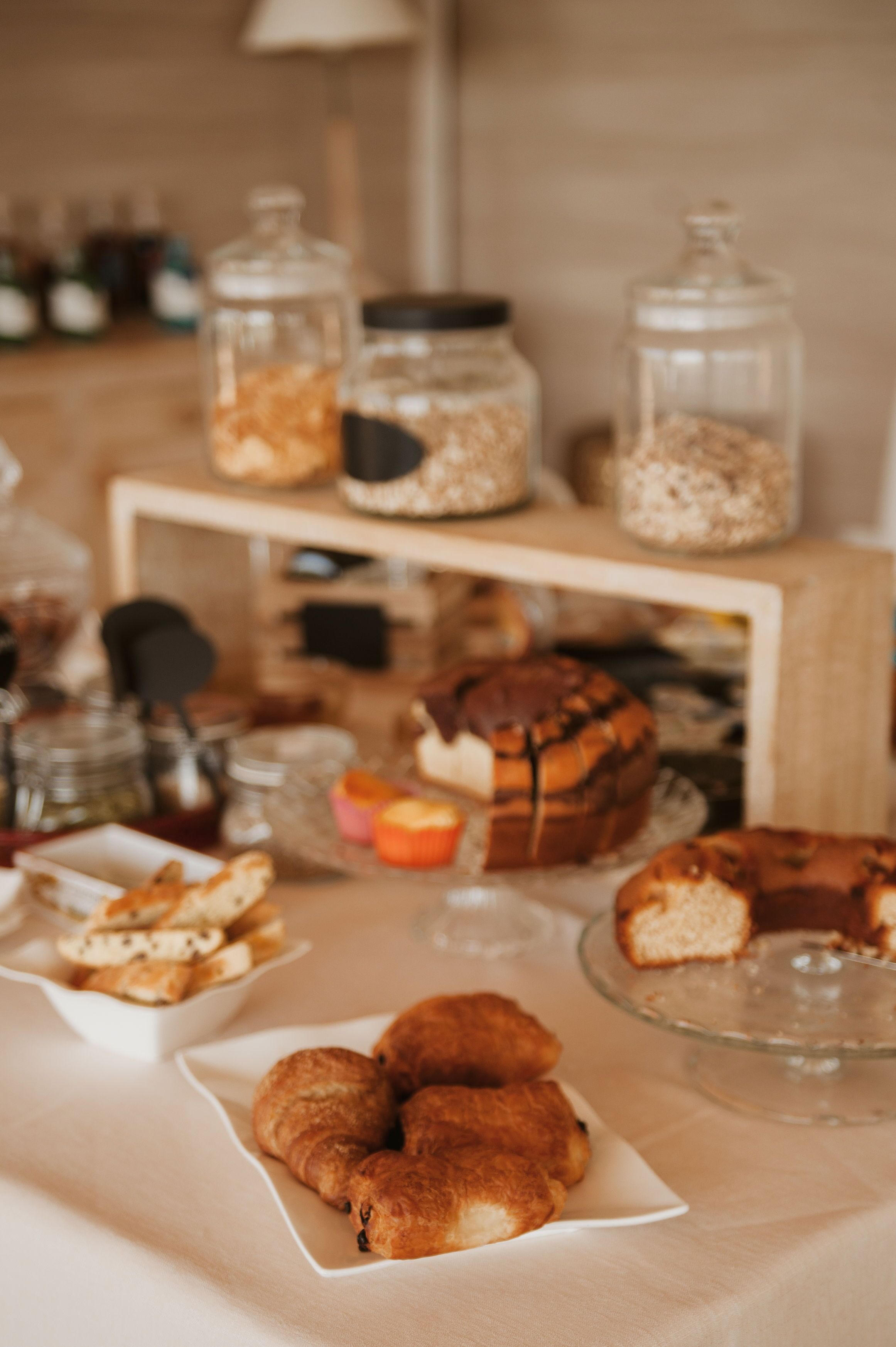 A table with various baked goods and jars of ingredients.