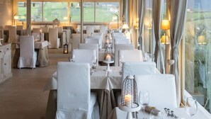 A spacious dining area with high ceilings and large windows, featuring tables set for dining and ambient lighting. - Relais Colle Buono (Alvito)