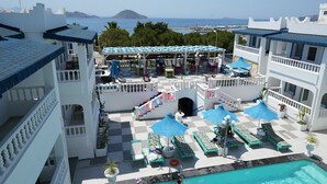 Un resort con piscina, mobiliario exterior y vistas al mar.